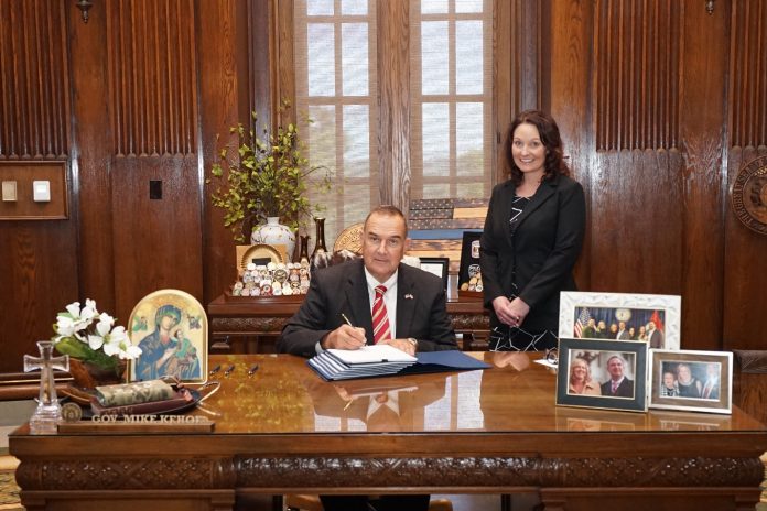 State Rep. Ann Kelley stands next to Governor Mike Kehoe for the signing of SB 150